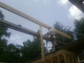 Carpenter setting a ridge beam over a new addition frame — Ice Dam Removal by Roofing Brothers in Knightstown