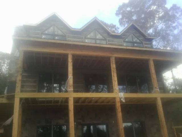 Dormers and porch framing on a large log home under construction — Roof Coating work by our crew in Knightstown
