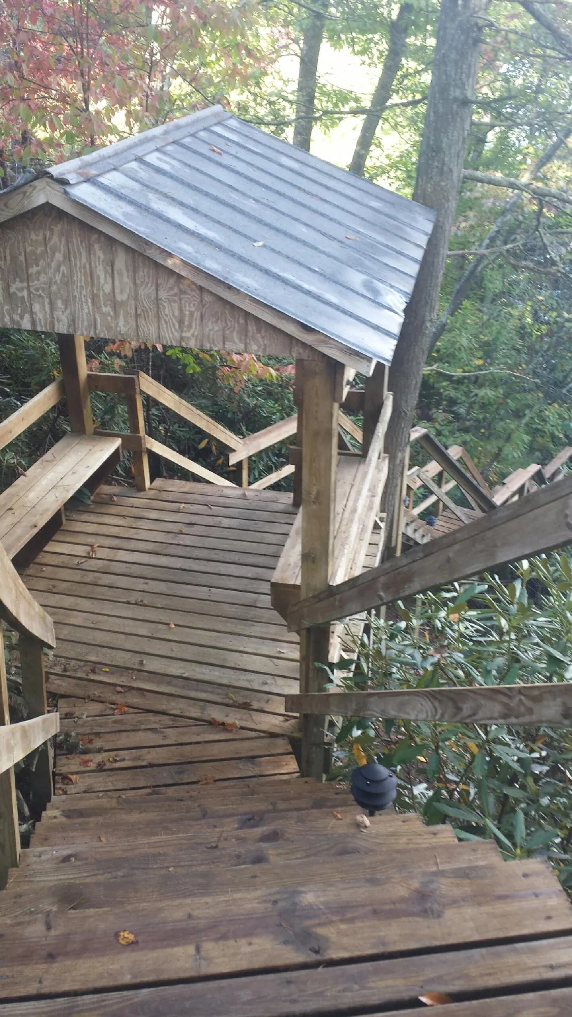 Metal roofed shelter over wooden steps on a wooded walkway — Skylight Repair & Installation work by our crew in Knightstown