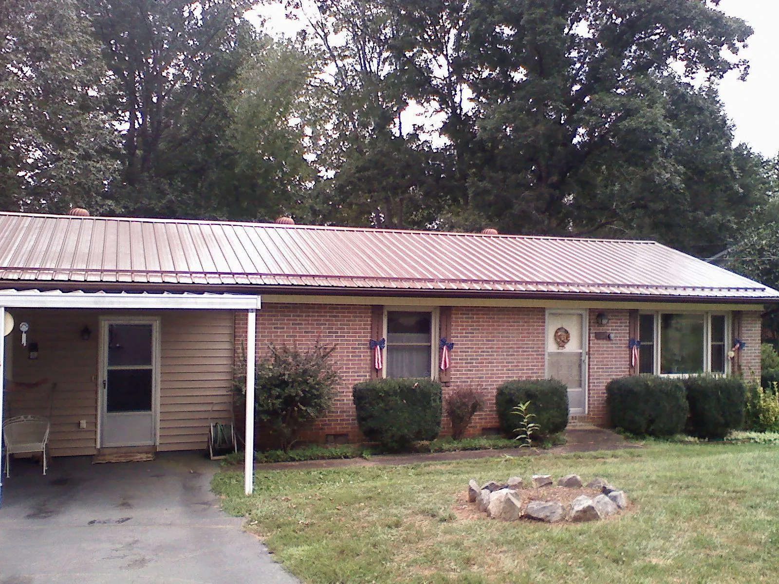 Bronze metal roof and carport on a brick ranch home — Roof Repair work by our crew in Knightstown